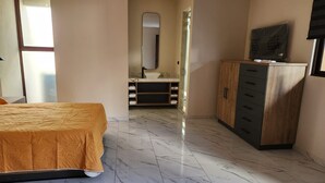 A bedroom with a bed, a wardrobe, a vanity with a mirror, and a bathroom visible through an open door. - Hotel El Descanso (Bernal)