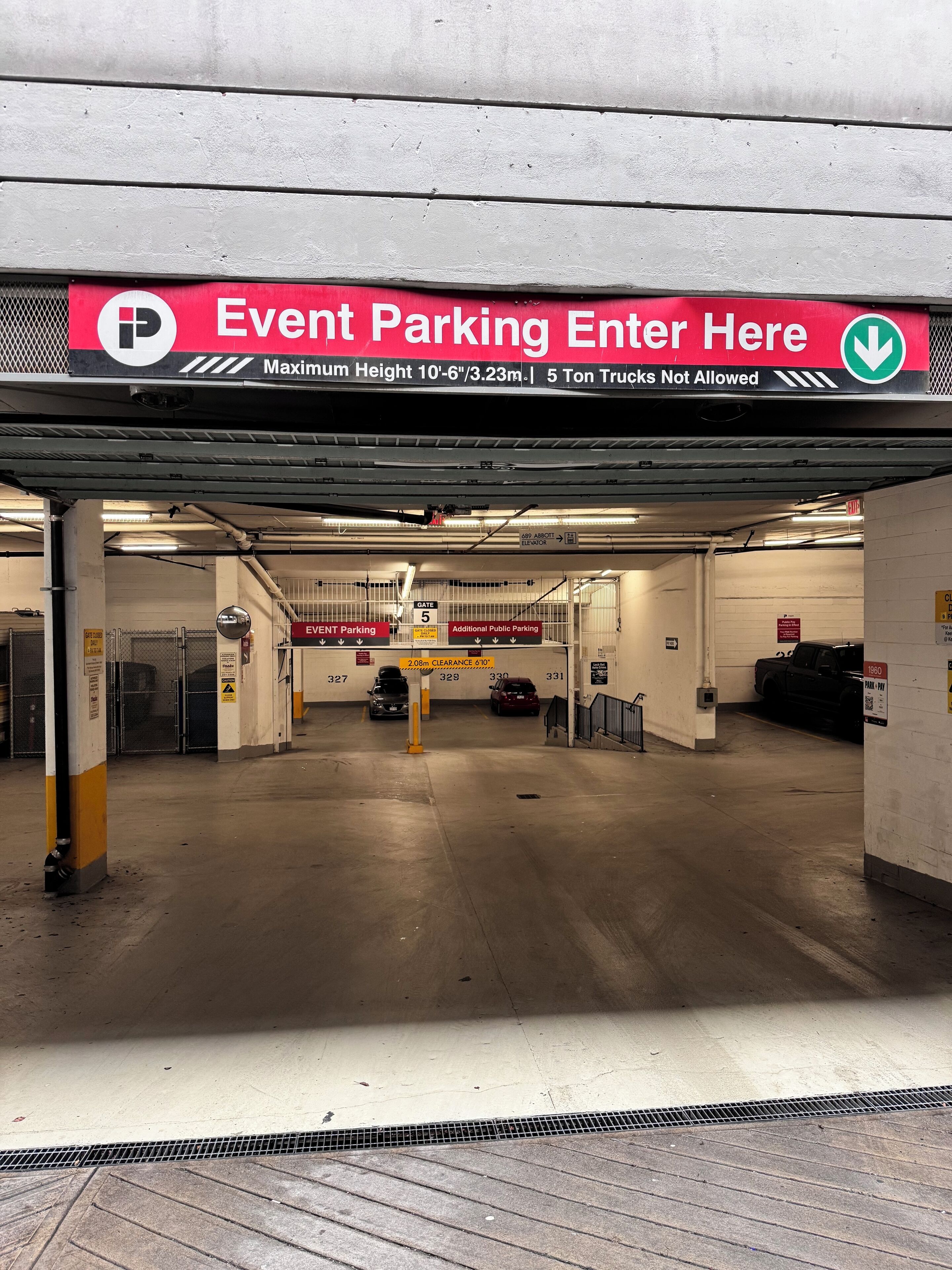 An underground parking garage with a sign indicating event parking and a maximum height restriction.