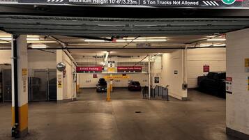 An underground parking garage with a sign indicating event parking and a maximum height restriction.