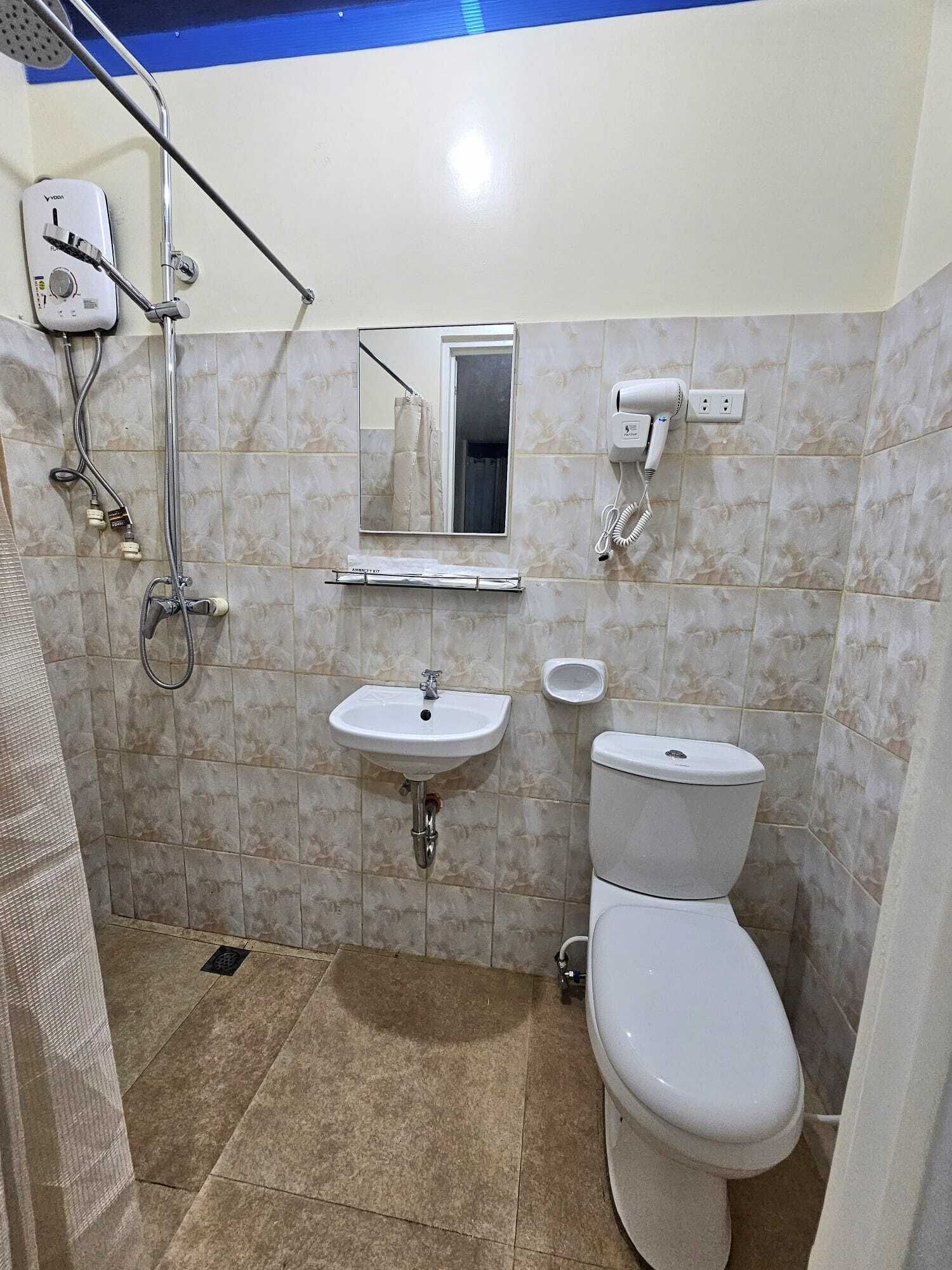 Une salle de bain avec une douche, un lavabo et des toilettes.