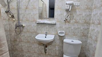 Une salle de bain avec une douche, un lavabo et des toilettes.