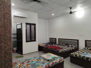 A bedroom with two beds, a wardrobe, and an air conditioning unit. - Khatu Shyam Niwas (Danta Ramgarh)