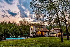 A two-story house with a swimming pool, surrounded by trees and a well-maintained lawn. - Couple s Oasis Pool Stream Firepit Steam Room (Saugerties)