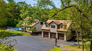A residential area with a house featuring a garage, a swimming pool, and a well-maintained lawn. - Couple s Oasis Pool Stream Firepit Steam Room (Saugerties)