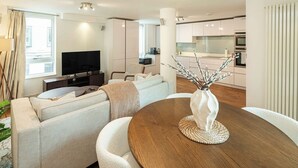 A modern living room with a sofa, TV, and dining table.