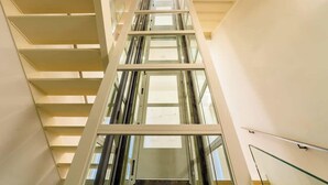 Un intérieur à plusieurs niveaux, doté de rampes en verre et d’une architecture moderne.