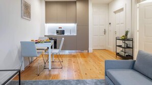 Un espacio habitable compacto con kitchenette, comedor y zona de estar.