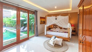 Une chambre avec un lit à baldaquin, une vue sur une piscine et une armoire en bois.