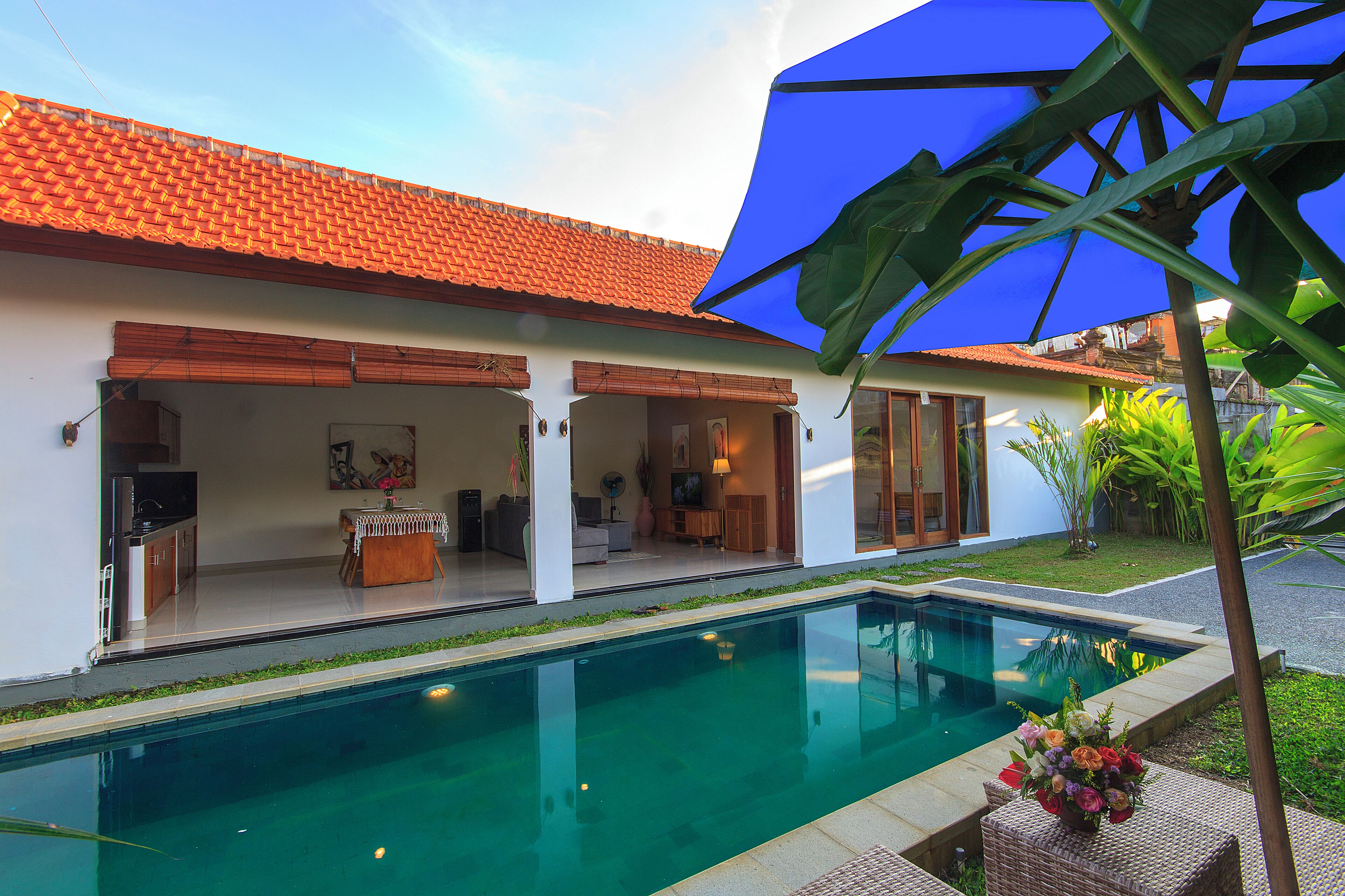 A swimming pool with a tiled roof and a covered patio area.
