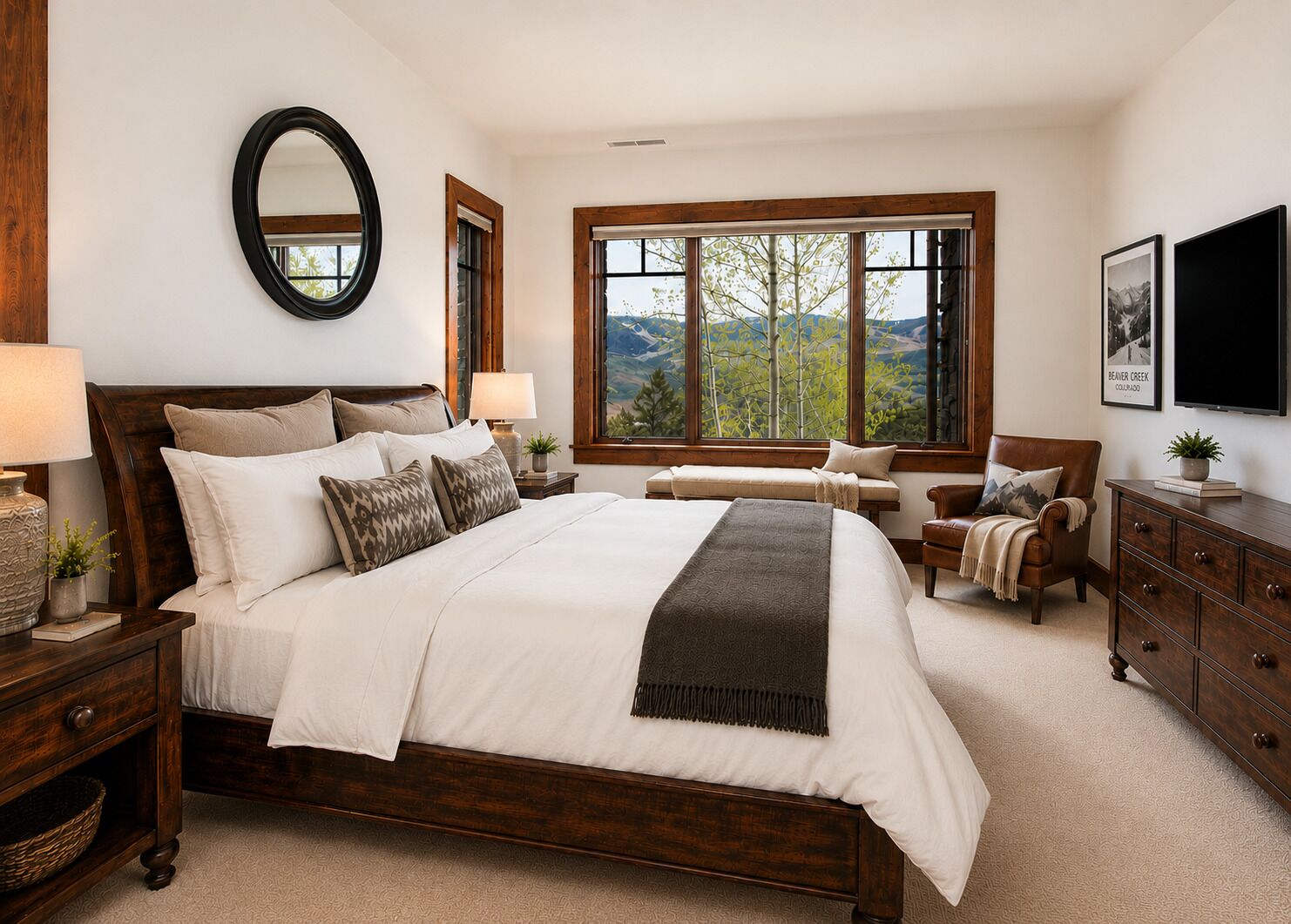 A bedroom with a large bed, a wooden headboard, a window with a mountain view, a bedside table with a lamp, and a dresser.
