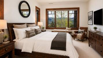 A bedroom with a large bed, a wooden headboard, a window with a mountain view, a bedside table with a lamp, and a dresser.