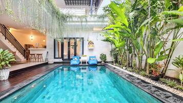 Una piscina al aire libre, sillones reclinables de piscina