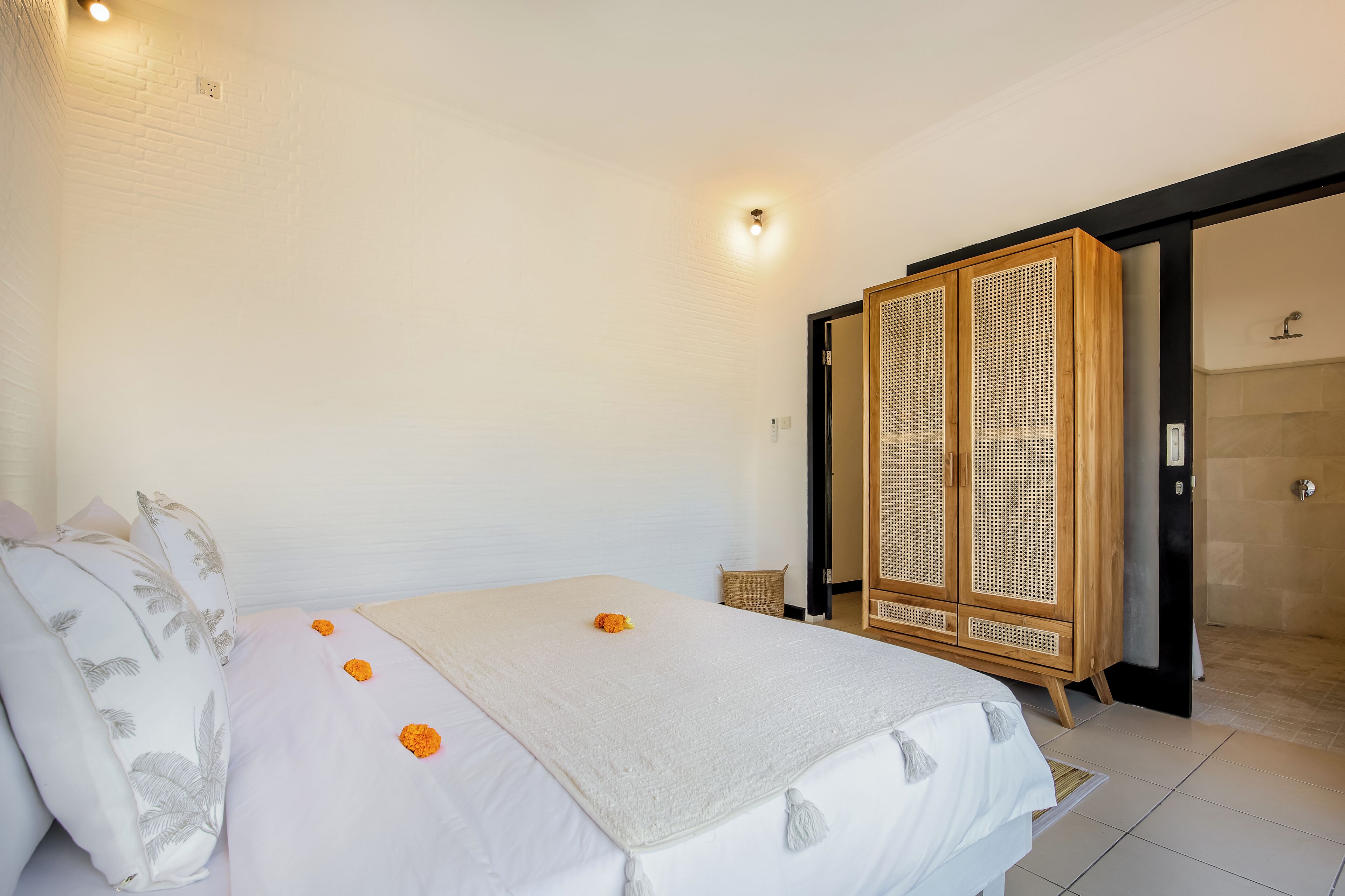 Habitación de hotel con cama, armario y zona de ducha.