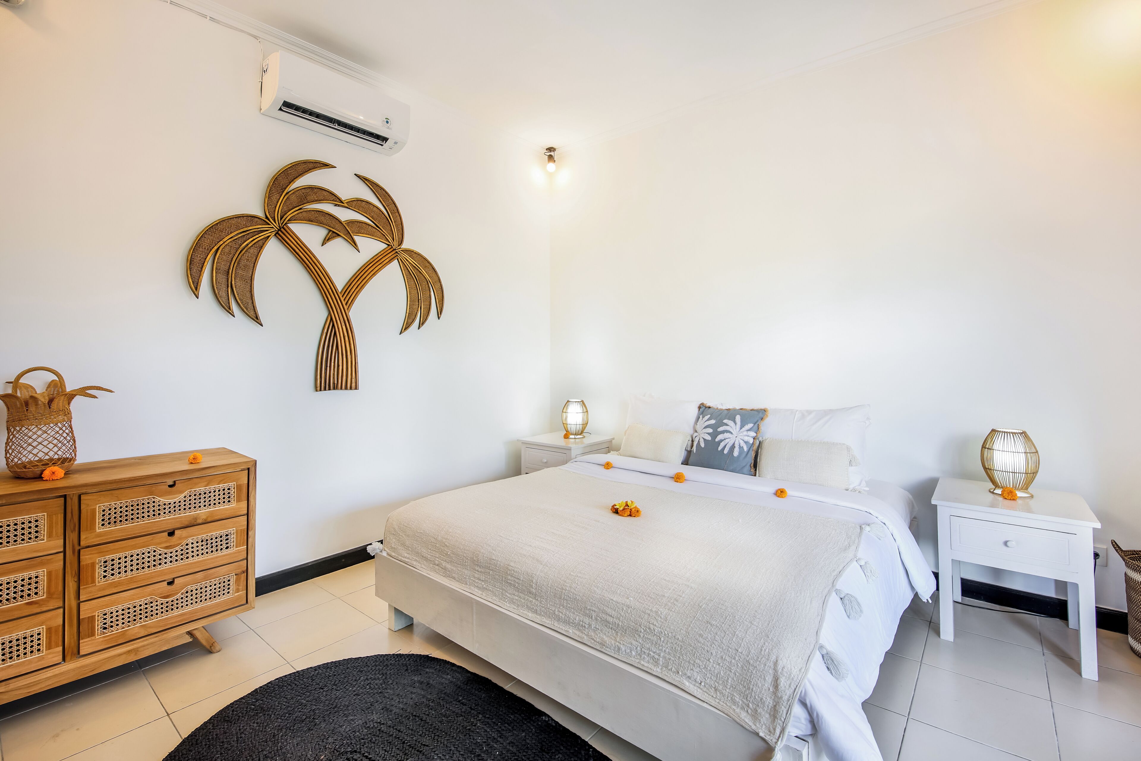 A bedroom with a bed, a nightstand, a dresser, and a wall-mounted air conditioner.