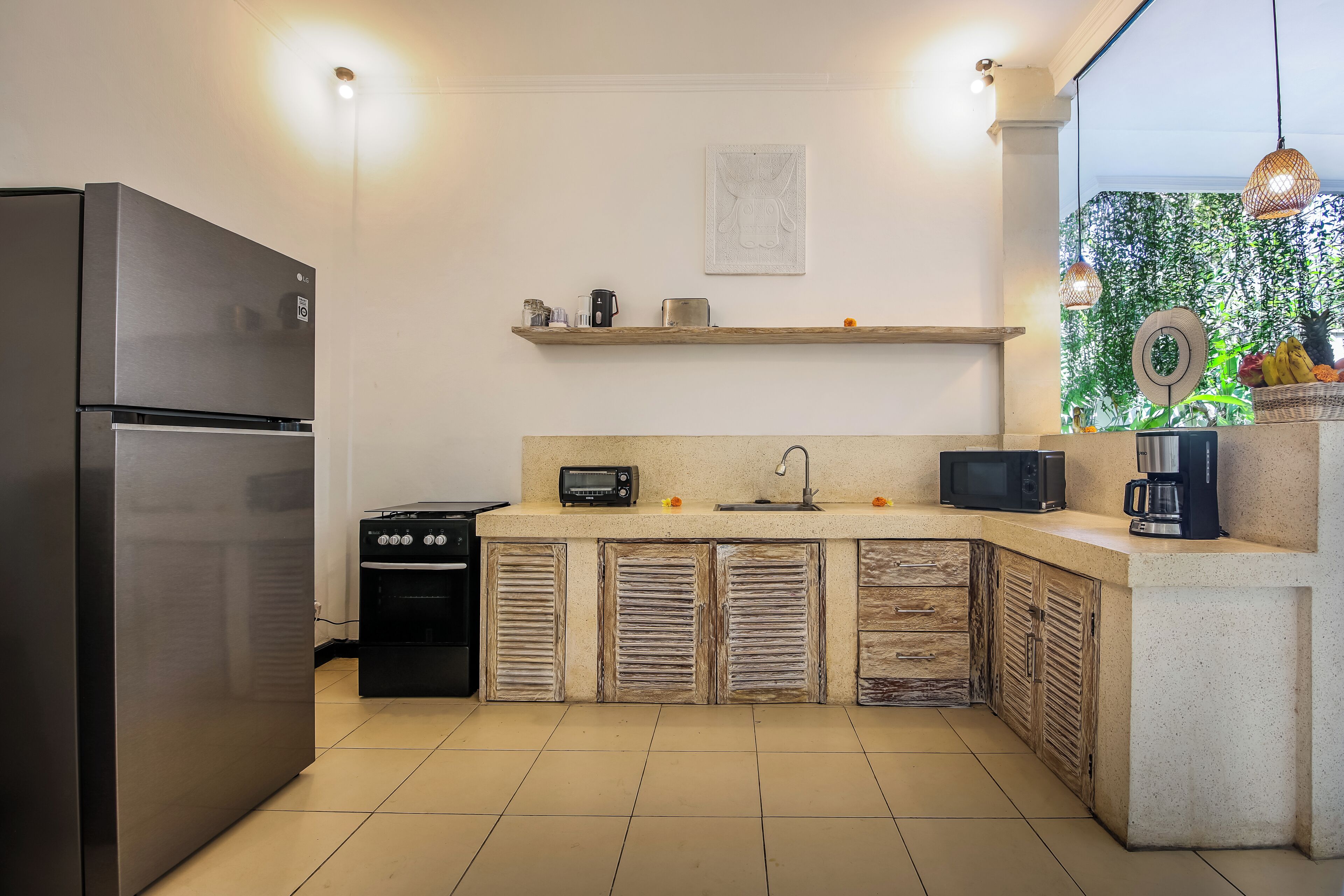 Een keuken met een roestvrijstalen koelkast, een broodrooster, een magnetron en een koffiezetapparaat op het aanrecht.