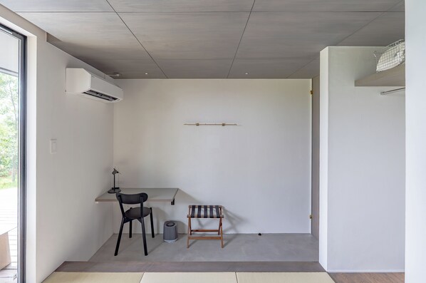 A minimalist room with a desk, chair, and a small bench. - Dei Amami (Amami)