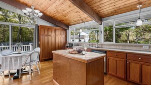 A spacious kitchen with wooden cabinets, a large island, and a dining area with a table and chairs. - Relax at This Dog-Friendly Sandwich Retreat (Sandwich)