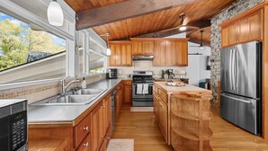 A modern kitchen with wooden cabinets, stainless steel appliances, and a large island. - Relax at This Dog-Friendly Sandwich Retreat (Sandwich)