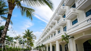 A hotel with a long, straight facade, multiple balconies, and a series of windows. - Gloca Phu Quoc (Duong To)
