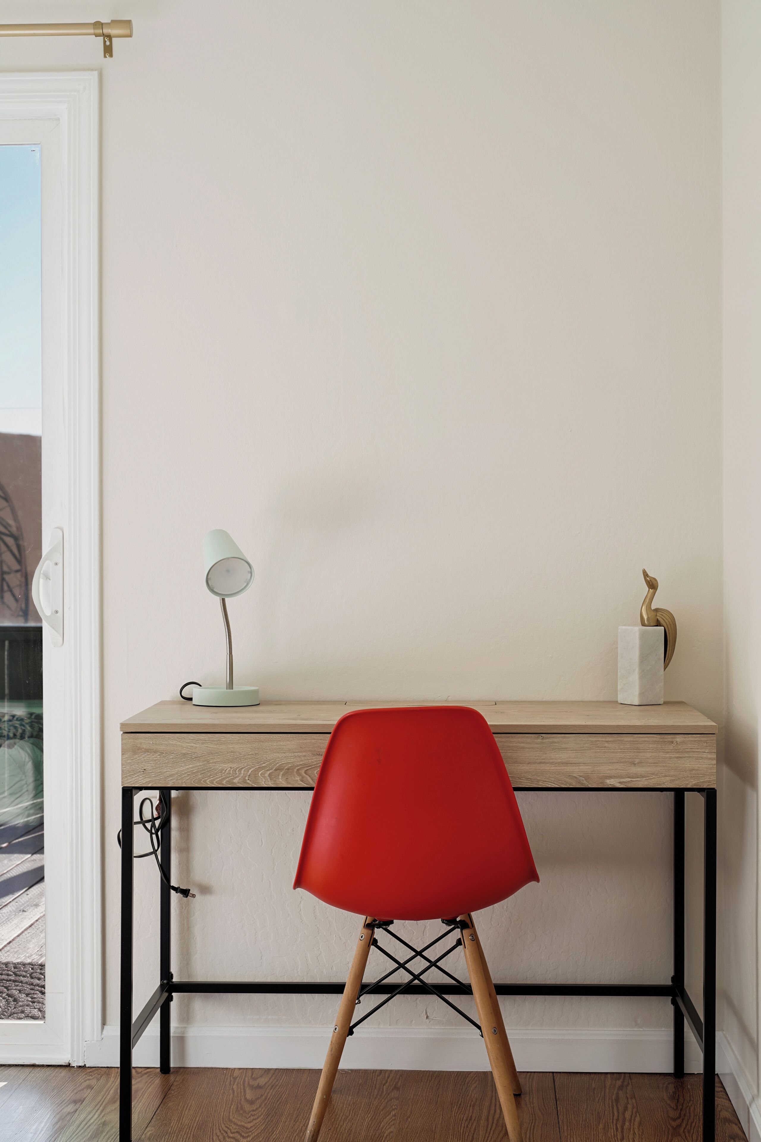 A desk with a lamp, a chair, and a decorative item.