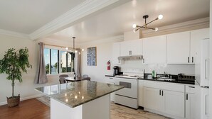 Una cocina moderna con armarios blancos, una isla central y una estufa integrada.
