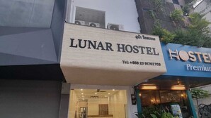 Un edificio con un letrero que dice 'LUNAR HOSTEL' y otro letrero que dice 'HOSTEL Premium'.