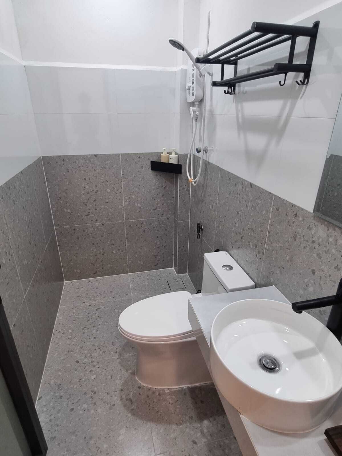 A bathroom with a toilet, sink, and shower.