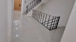 Una escalera moderna con barandilla metálica que conduce a un piso superior.