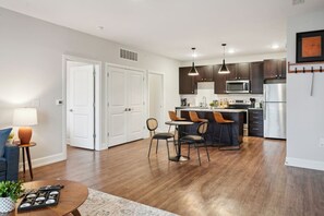Una cocina moderna con armarios de madera oscura, un refrigerador de acero inoxidable y una isla central con taburetes de bar.