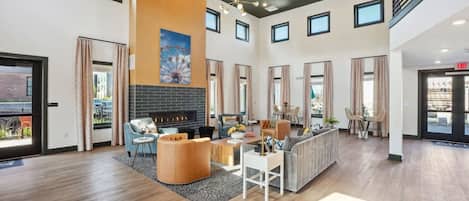 A spacious living area with a fireplace, seating arrangements, and a view of the outside.