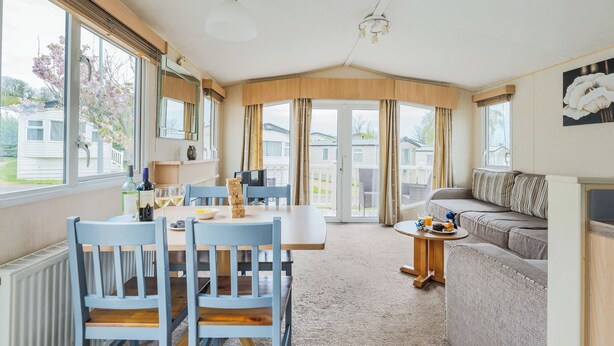 A cozy room with a dining table, chairs, a sofa, and a television.