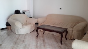 A living room with a sofa, a chair, and a coffee table. - Melat Guest House (Addis Ababa)