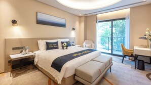 A modern hotel room with a large bed, bedside tables, a desk, and a view of the outdoors. - Mulianzhuang Hotel FrontierMedicalCenter (Chengdu)