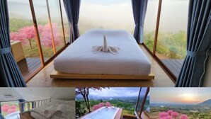 Ein Zimmer mit einem Bett, großen Fenstern und Blick auf Kirschblüten.