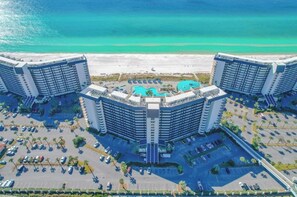 A high-rise hotel with a rooftop pool, adjacent to a beach.