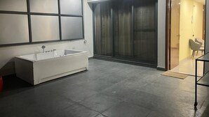 A modern bathroom with a large bathtub, a glass shower enclosure, and a visible toilet.