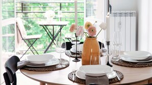 A dining table set with plates, glasses, and a vase with flowers.