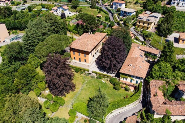 An aerial view of a residential area with houses, trees, and a winding road.