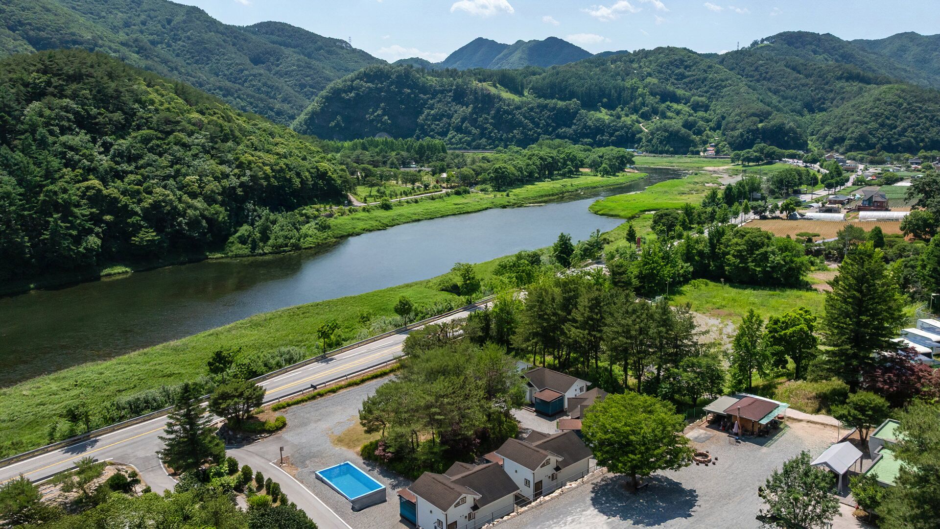 Zona residencial con río, casas y piscina.