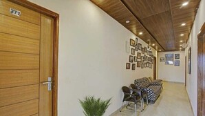 A hallway with a wooden door labeled "277", a potted plant, and a sofa with patterned cushions. - Himalayan View stay (Mussoorie)