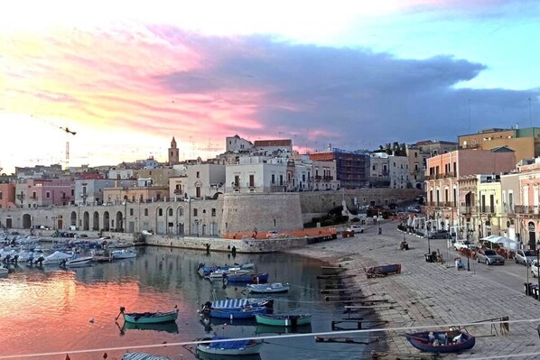 A coastal town with a historic waterfront, boats docked along the pier, and buildings with traditional architecture.