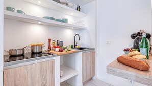 Una cocina moderna con estufa integrada, un fregadero y una encimera con distintos utensilios de cocina.