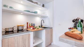 Une cuisine moderne équipée d’une cuisinière intégrée, d’un évier et d’un plan de travail sur lequel sont disposés divers ustensiles de cuisine.