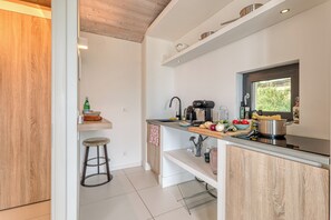 Une cuisine moderne dotée d’un plan de travail en bois, d’un évier et de divers ustensiles de cuisine.