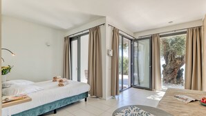 Un dormitorio moderno con cama, mesita de noche y vistas a un paisaje natural a través de amplios ventanales.
