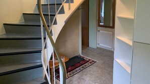 A staircase with a metal railing leading to a landing. There is a radiator on the wall and a patterned rug on the floor. - Holiday Home 'Durst 1' with Mountain Views, Private Terrace and Wi-Fi (Mayrhofen)