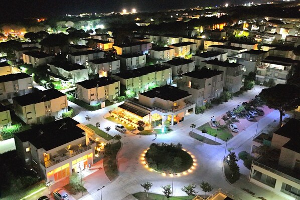 A residential area with modern apartment buildings, a central roundabout, and well-lit streets. - Perla Holiday Villa 150, Lalzit Bay, Albania (Lalzit Bay)