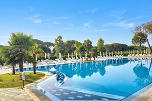 A swimming pool with lounge chairs and palm trees. - Perla Holiday Villa 150, Lalzit Bay, Albania (Lalzit Bay)