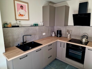 A modern kitchen with a sink, countertop, cabinets, a kettle, and an oven. - das moselquartier terlinden – Apartment on the Moselle Promenade, Perl-Besch (Perl-Besch)