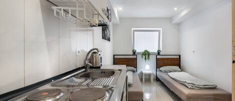 A compact kitchen with a stove, sink, and a small dining area.